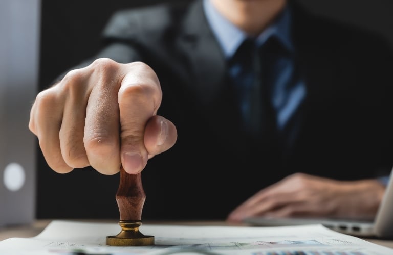 Man is putting stamp in document